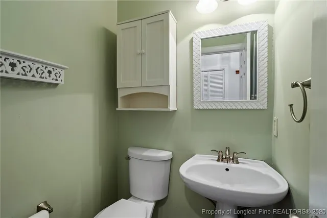 a bathroom with a sink a toilet and mirror
