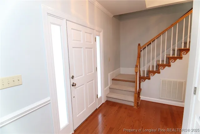 a view of a hallway with wooden floor and entryway
