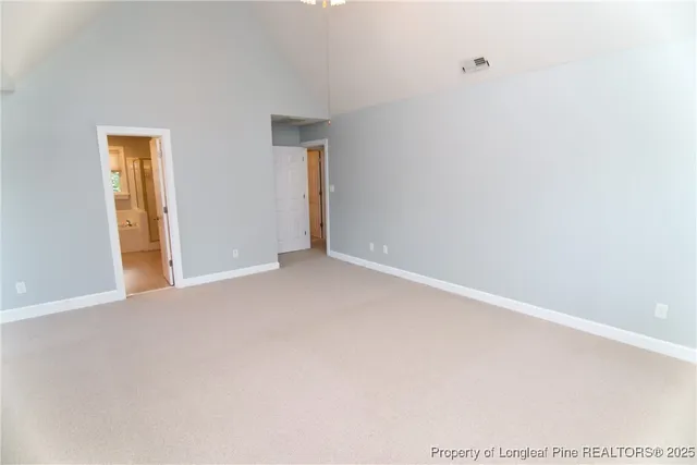 a view of an empty room with a chandelier fan