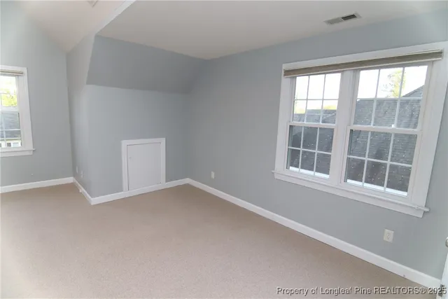 an empty room with a ceiling fan and a window