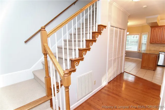 a view of staircase with lots of frames on wall and wooden floor
