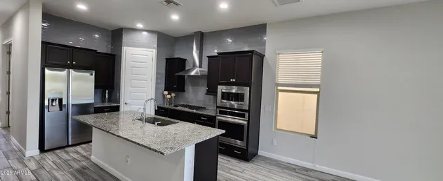 a kitchen with stainless steel appliances granite countertop a refrigerator and a stove