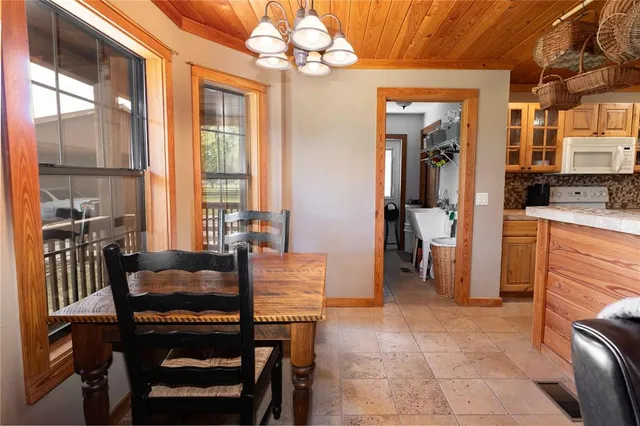 a dining room with furniture a chandelier and wooden floor