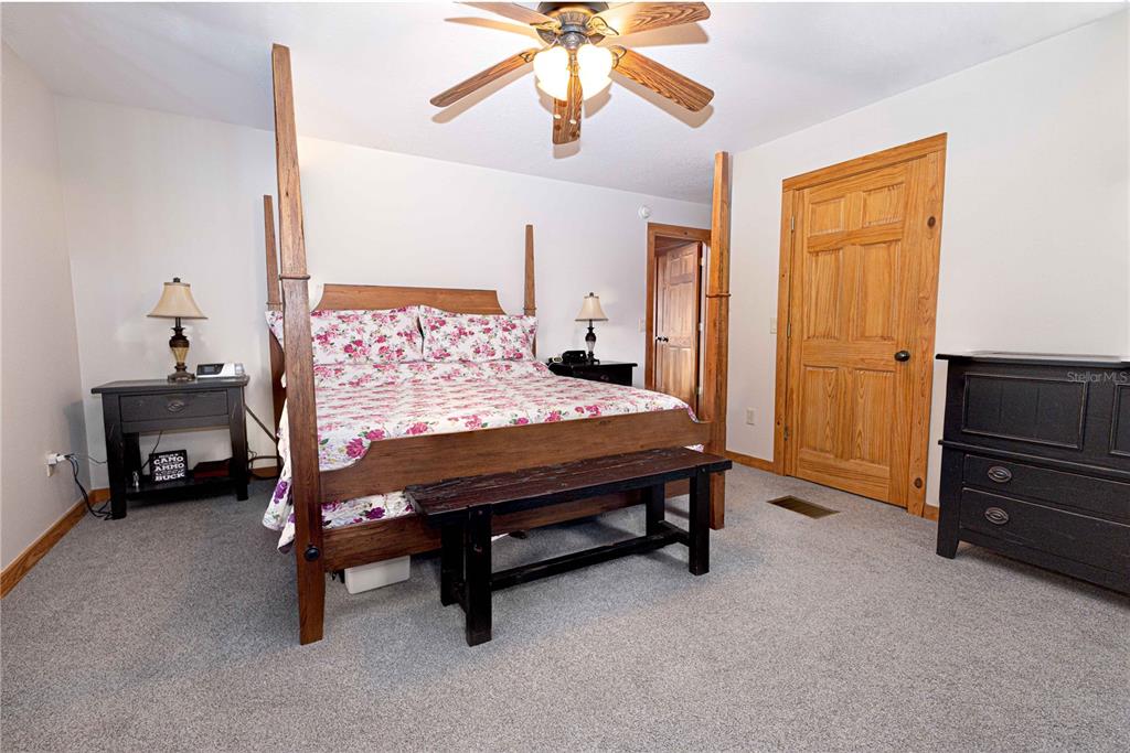 8091 County Road 476B Bushnell, FL 33513 - Photo 23 of 67 a bedroom with a bed and a chandelier