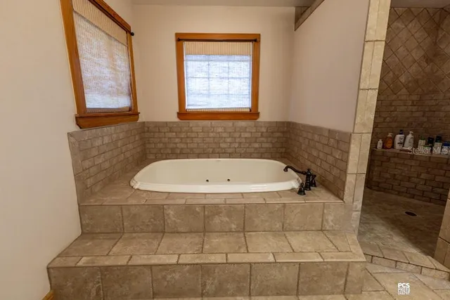 an empty room with windows and ceiling fan