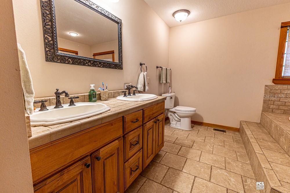8091 County Road 476B Bushnell, FL 33513 - Photo 29 of 67 a spacious bathroom with a double vanity sink toilet and a mirror