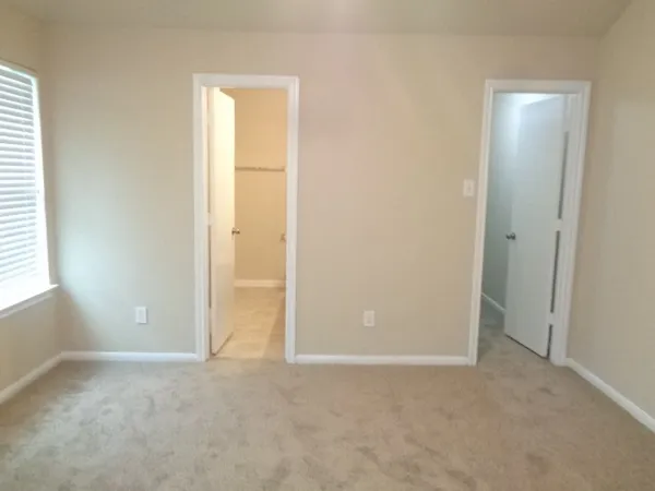 an empty room with windows and closet