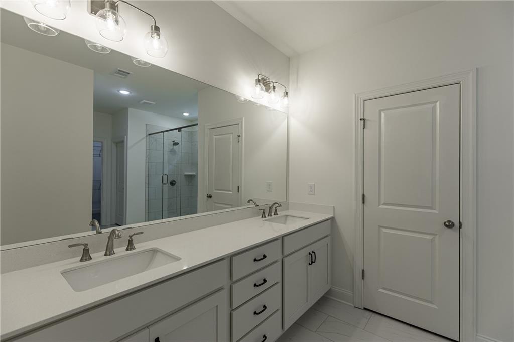 1210 Austin Road Winder, GA 30680 - Photo 39 of 56 a bathroom with double vanity sinks and a mirror