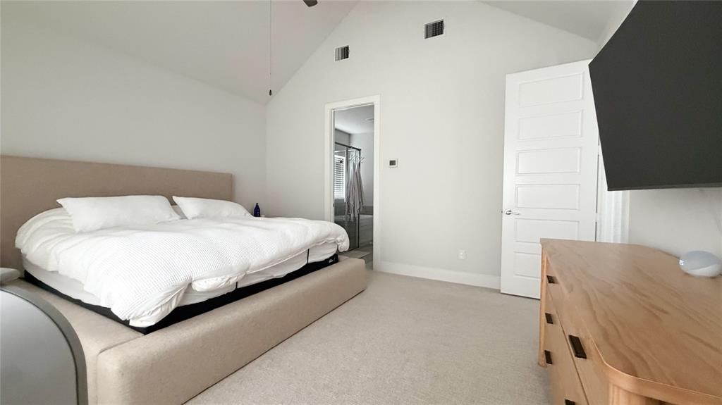 3201 Calvin Road McKinney, TX 75071 - Photo 8 of 11 Spacious bedroom featuring vaulted ceilings, light-colored carpeting, and a crisp white five-panel interior door