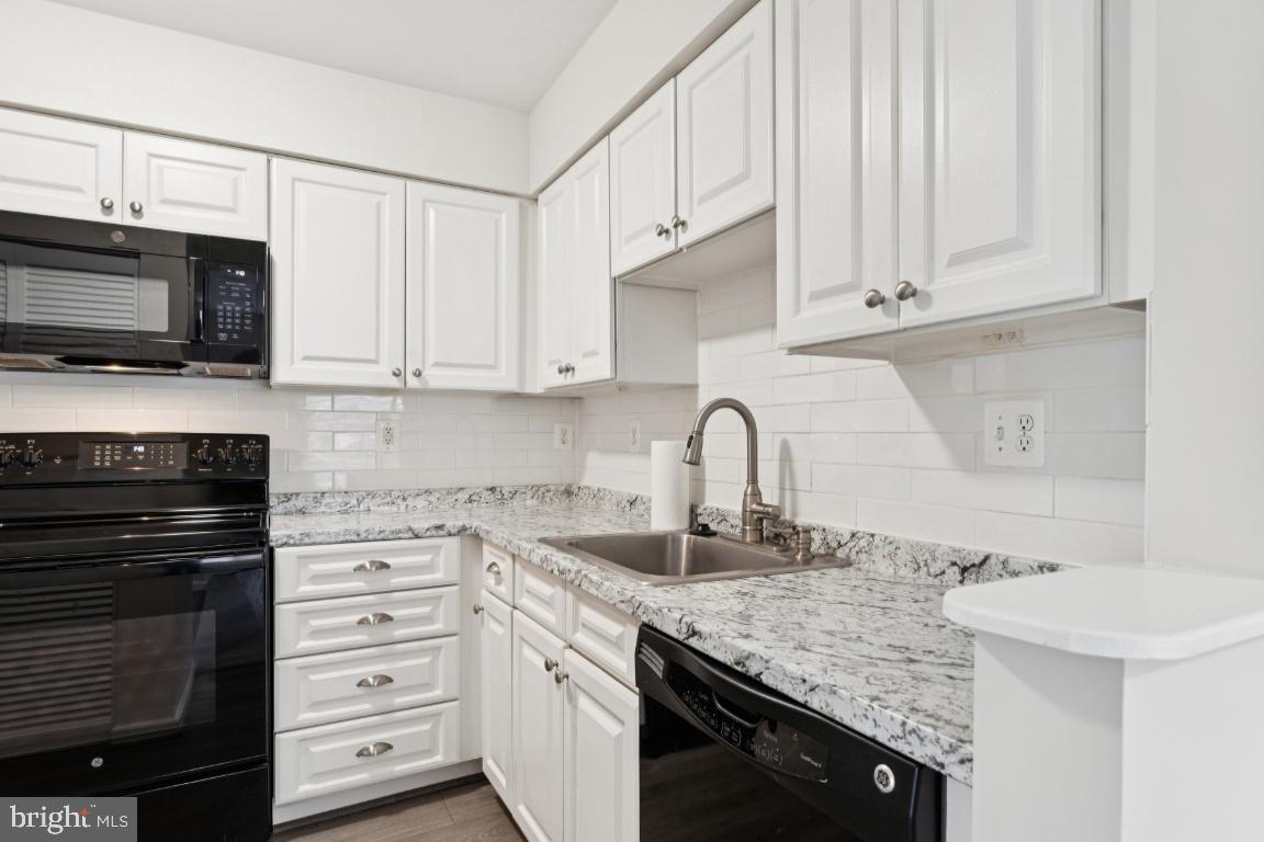 13 Ohara Court Olney, MD 20832 - Photo 12 of 25 a kitchen with granite countertop a sink dishwasher stove and microwave with wooden cabinets