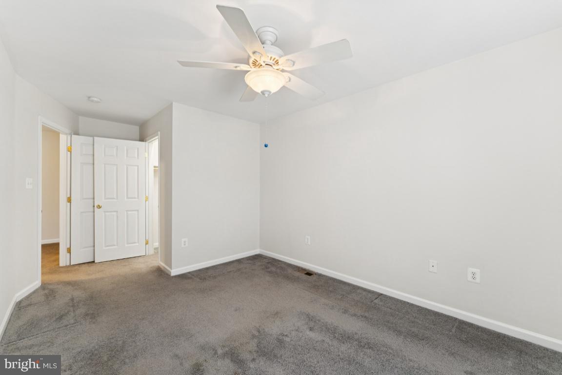 13 Ohara Court Olney, MD 20832 - Photo 17 of 25 an empty room with a chandelier fan and windows
