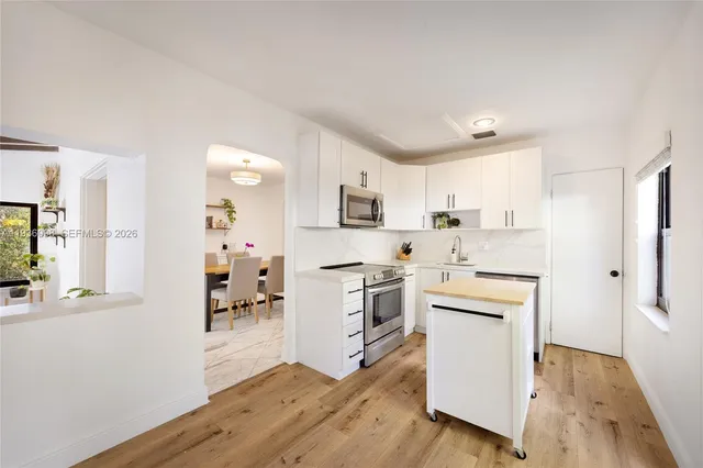 a kitchen with white cabinets and stainless steel appliances