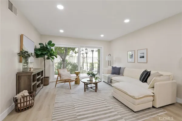 a living room with furniture a fireplace and potted plants