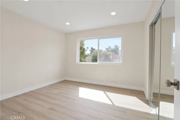 an empty room with wooden floor and window