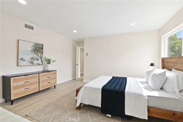 a bedroom with a bed and painting on the wall