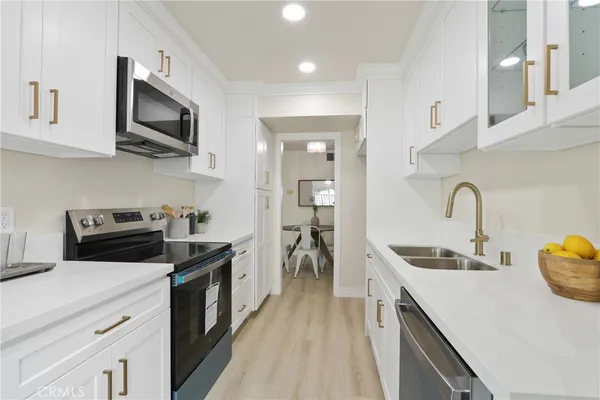 a kitchen with stainless steel appliances a sink stove and microwave