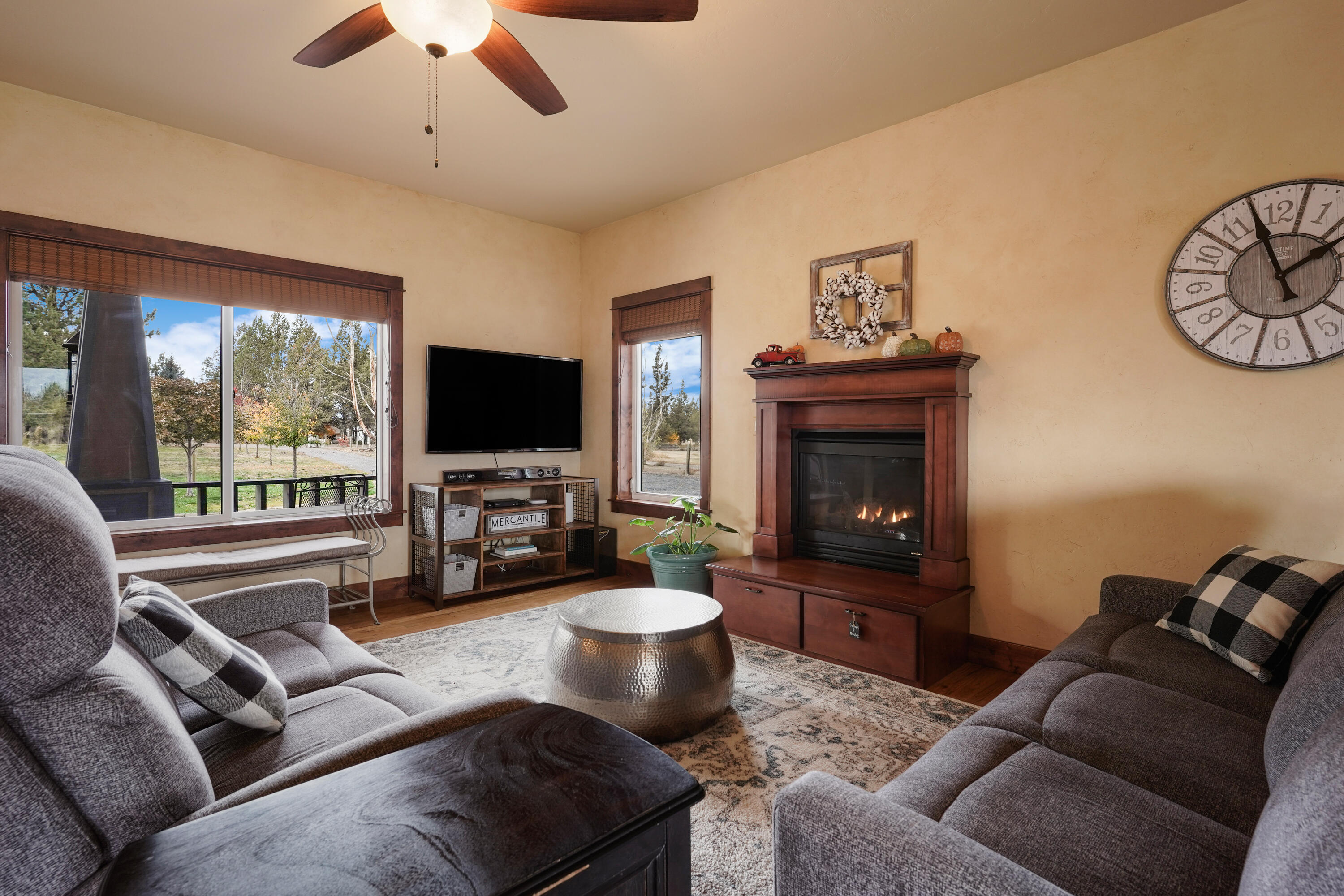63520 Cricketwood Road Bend, OR 97701 - Photo 59 of 84 a living room with furniture a large window and a flat screen tv