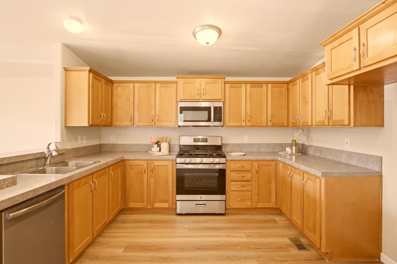 145 Dory Lane Modesto, CA 95356 - Photo 9 of 27 a kitchen with stainless steel appliances granite countertop a stove a sink and a microwave