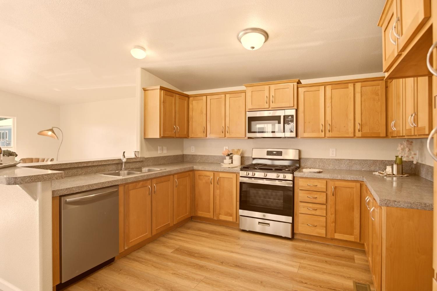 145 Dory Lane Modesto, CA 95356 - Photo 10 of 27 a kitchen with stainless steel appliances granite countertop a stove a sink and a microwave