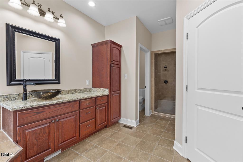 2751 Buie - Philadelphus Road Pembroke, NC 28372 - Photo 14 of 30 a bathroom with a granite countertop sink a mirror and a shower