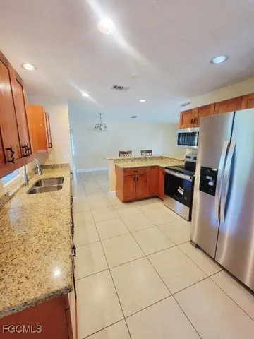 a kitchen with stainless steel appliances granite countertop a refrigerator and a stove