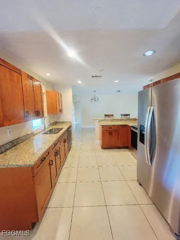a kitchen with stainless steel appliances granite countertop a refrigerator and a stove top oven