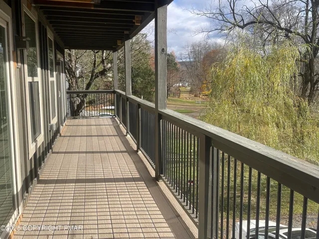 an empty room with wooden floor and windows with curtains