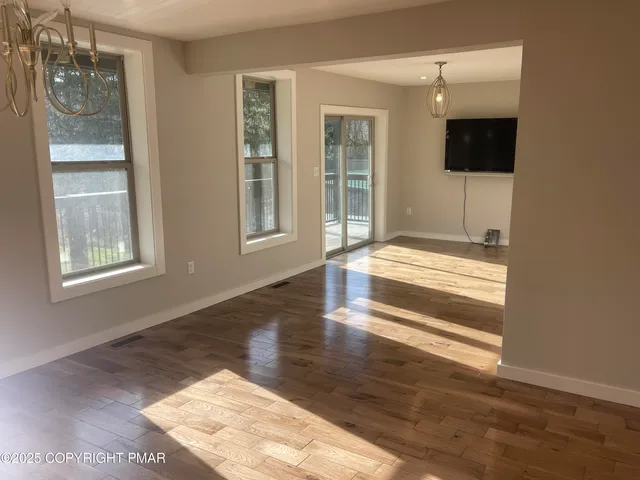 a view of hallway with a flat screen tv and a floor to ceiling window