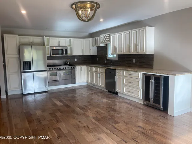 a kitchen with granite countertop a stove a sink and a microwave