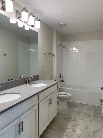 a bathroom with a double vanity sink toilet and a mirror