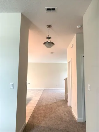 a view of a hallway with a dining table and chair
