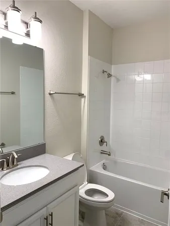 a bathroom with a granite countertop sink toilet a mirror and shower