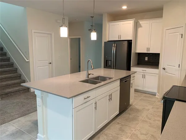 a kitchen with a sink a refrigerator and a stove top oven