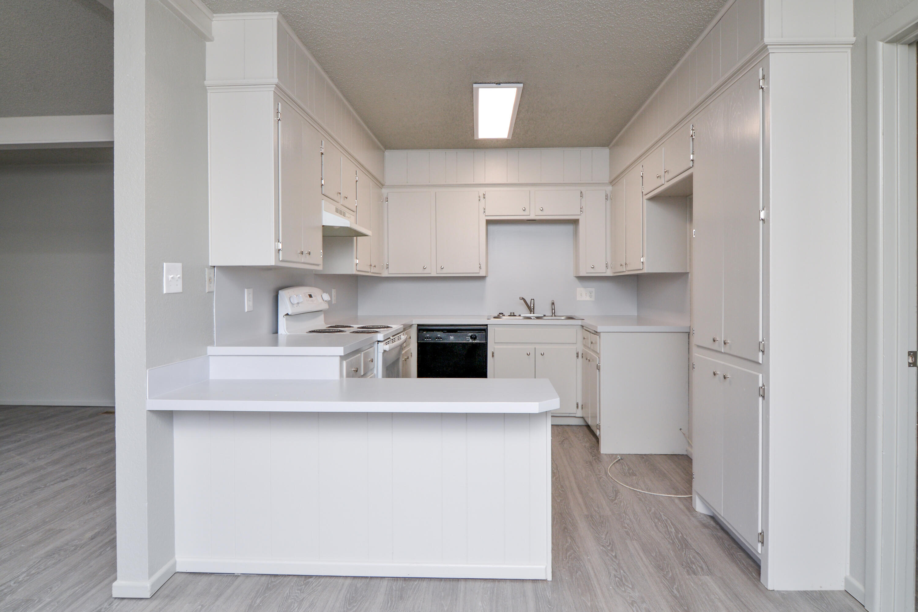 3714 53rd Street, Unit A & B Lubbock, TX 79413 - Photo 11 of 28 a kitchen with stainless steel appliances granite countertop a sink a stove a refrigerator and white cabinets with wooden floor
