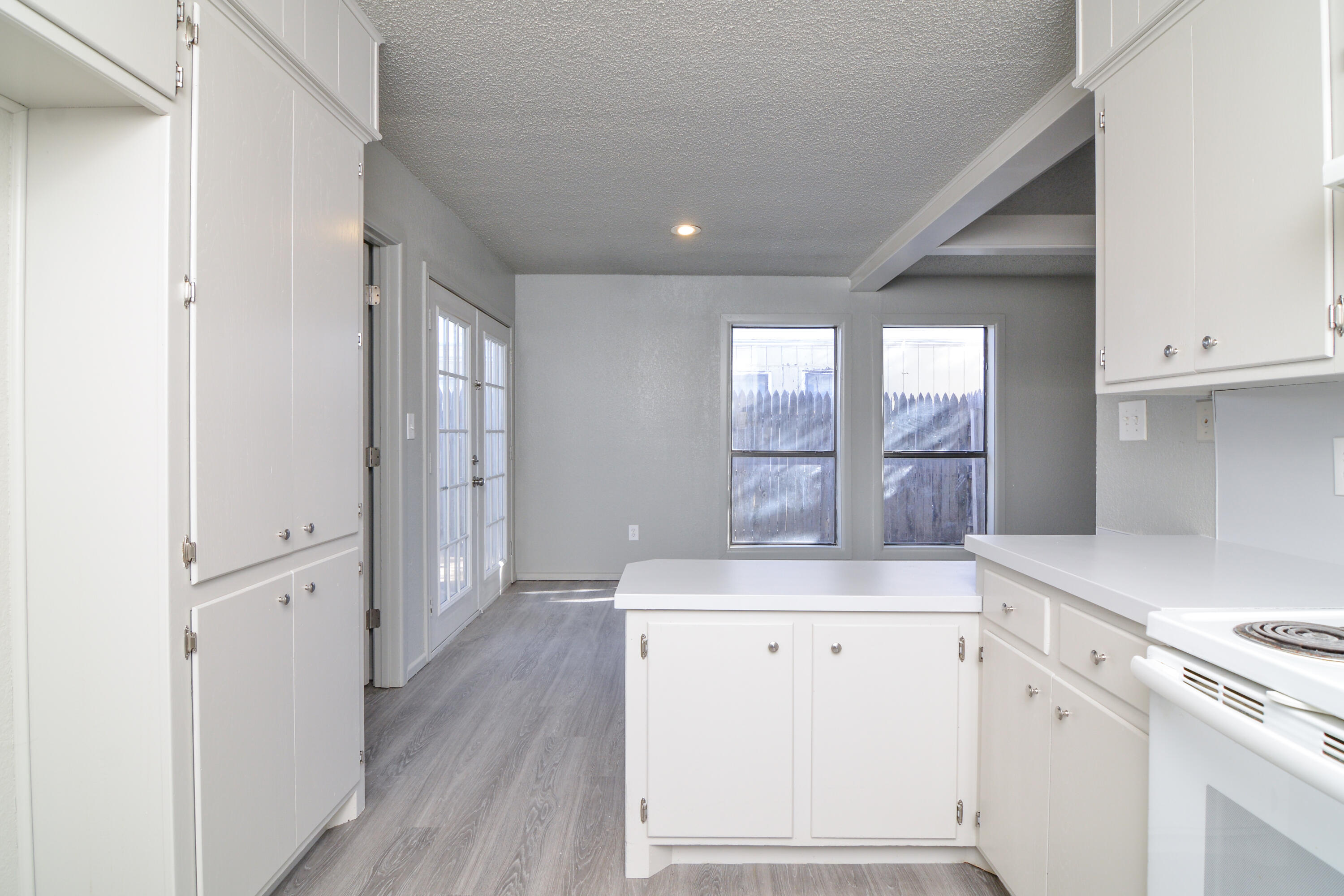 3714 53rd Street, Unit A & B Lubbock, TX 79413 - Photo 15 of 28 a view of a kitchen with white cabinets and wooden floor