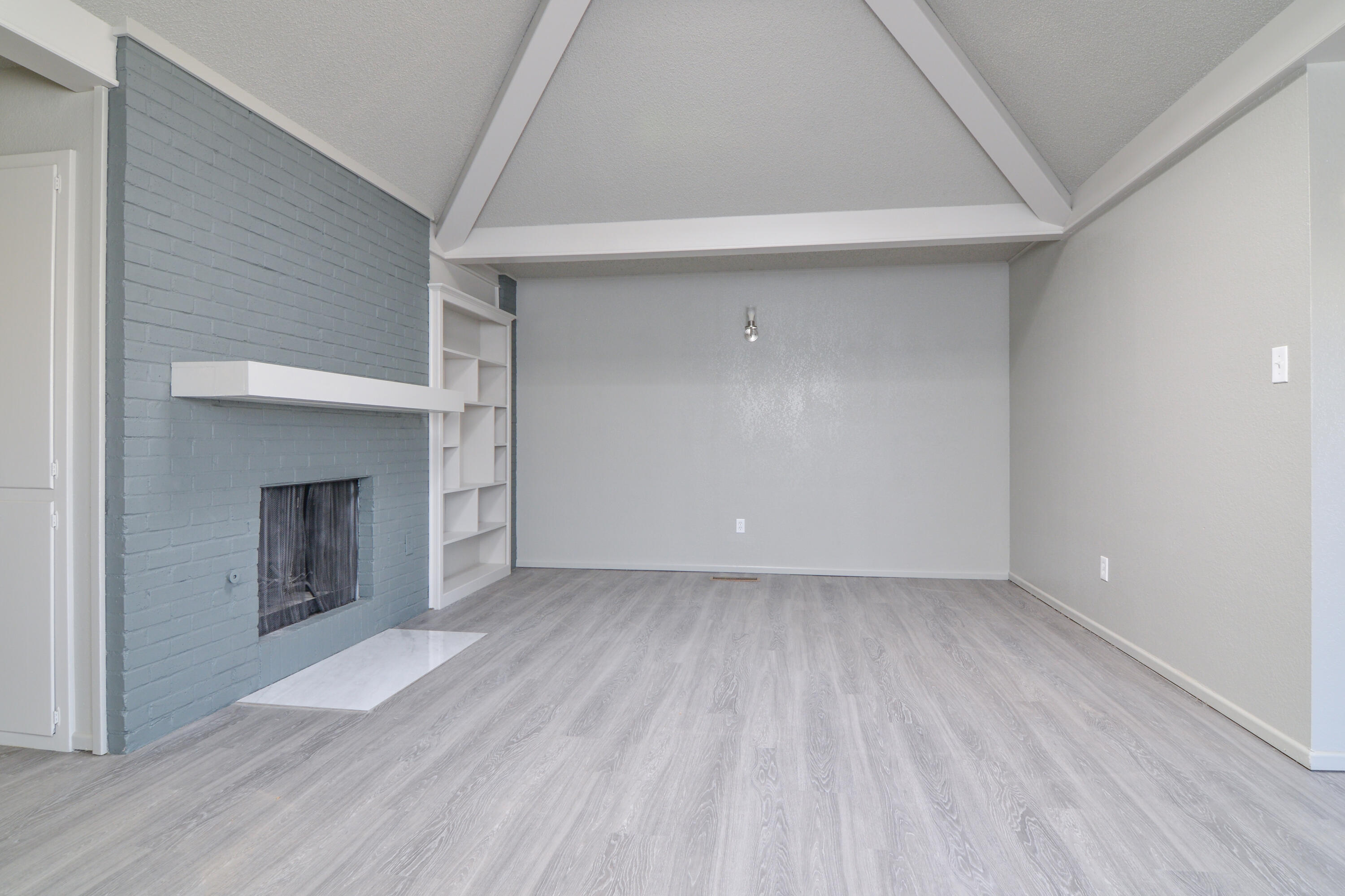 3714 53rd Street, Unit A & B Lubbock, TX 79413 - Photo 5 of 28 an empty room with a fireplace and wooden floor
