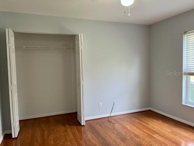 405 Arlington Avenue East Oldsmar, FL 34677 - Photo 18 of 21 an empty room with wooden floor and windows