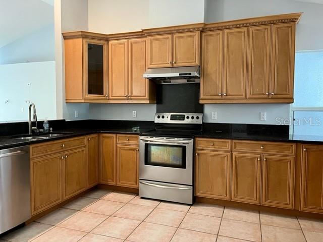 405 Arlington Avenue East Oldsmar, FL 34677 - Photo 7 of 21 a kitchen with granite countertop a stove a sink and a microwave