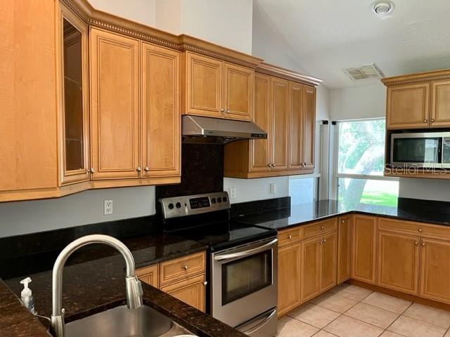 405 Arlington Avenue East Oldsmar, FL 34677 - Photo 8 of 21 a kitchen with granite countertop a stove a sink and a microwave