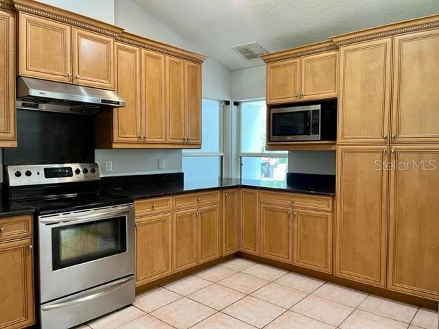 405 Arlington Avenue East Oldsmar, FL 34677 - Photo 10 of 21 a kitchen with stainless steel appliances granite countertop a stove microwave and refrigerator