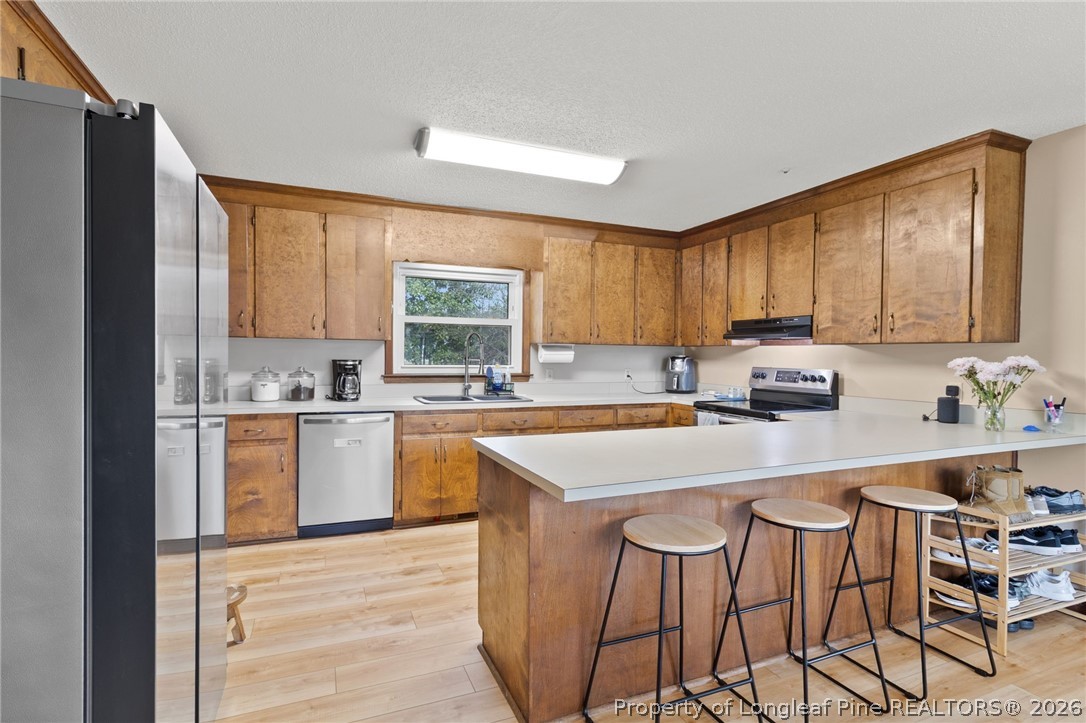 730 Slocomb Road Fayetteville, NC 28311 - Photo 13 of 48 a kitchen with stainless steel appliances granite countertop a sink a stove a refrigerator cabinets and a window