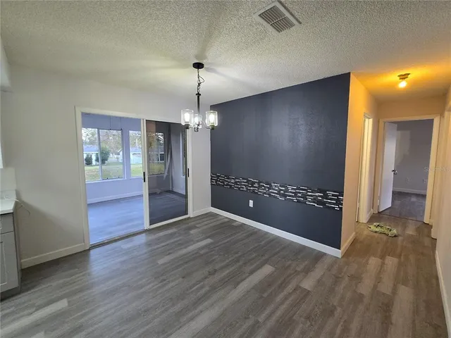 a view of a hallway with wooden floor and a livingroom
