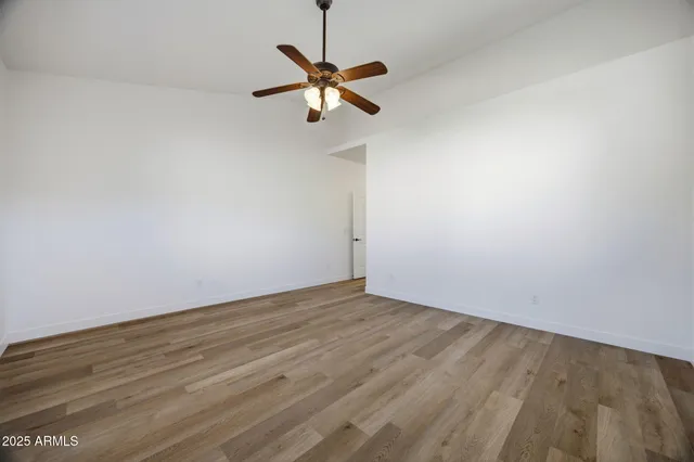 a view of room with a ceiling fan and wooden floor
