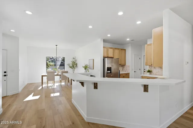 a view of a kitchen with kitchen island a sink a stove a dining table and chairs