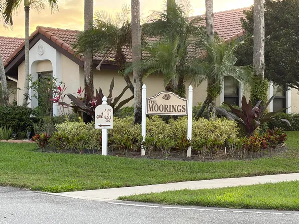 a front view of a house with a yard and potted plants