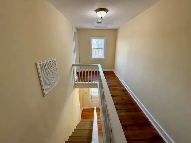 a view of a hallway with wooden floor and entryway