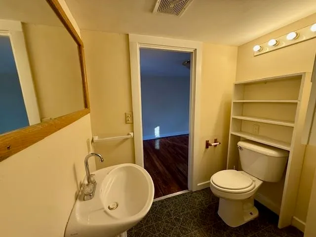 a bathroom with a toilet a sink and a mirror