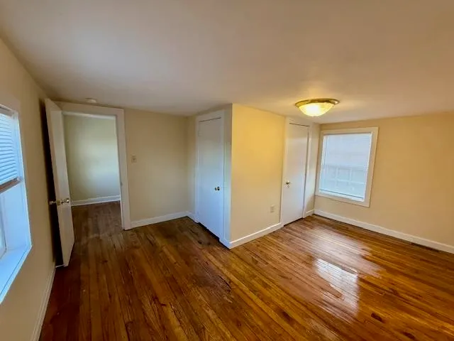 wooden floor in an empty room with a window