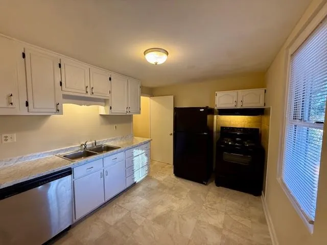 a kitchen with granite countertop a refrigerator and a stove top oven