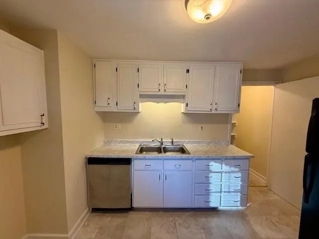 a kitchen with granite countertop a sink a stove and refrigerator